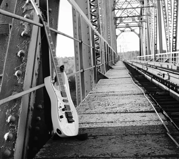 Guitarra elétrica preto e branco nas trilhas ferroviárias e pedra — Fotografia de Stock