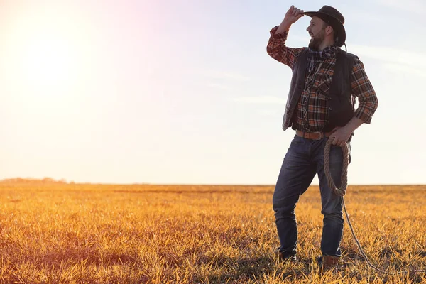 Un sombrero de vaquero y un loso en el campo. Granjero americano en una f — Foto de Stock
