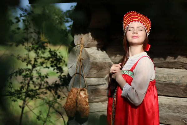 Chica en vestido tradicional pared de madera — Foto de Stock