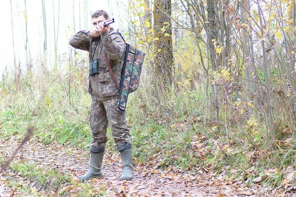 Człowiek w kamuflażu i z karabinami w pasie lasu na wiosnę hun — Zdjęcie stockowe