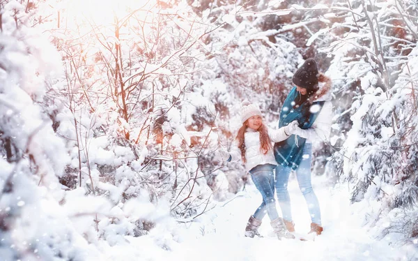 Una familia joven para dar un paseo. Mamá y su hija están caminando en un winte — Foto de Stock