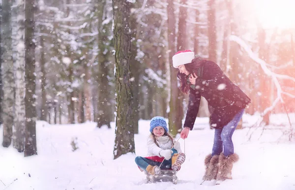 Un cuento de hadas de invierno, una joven madre y su hija montan en un trineo — Foto de Stock