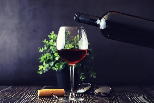 Una copa de vino tinto seco sobre la mesa. Botella oscura y vidrio de w — Foto de Stock