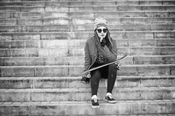Ένα νεαρό hipster κορίτσι είναι ιππασίας ένα skateboard. Κορίτσια φίλες f — Φωτογραφία Αρχείου
