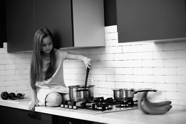 Mała dziewczynka w kuchni czarno-biała — Zdjęcie stockowe