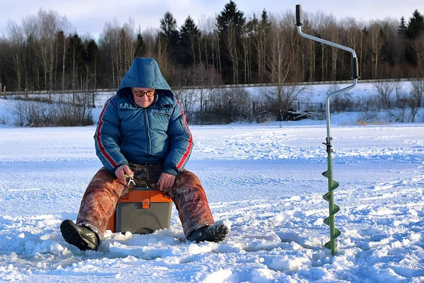 Anciano pescando en el invierno en el lago — Foto de Stock