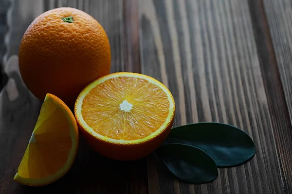 Sinaasappelcitrusvruchten op een stenen tafel. Oranje achtergrond. — Stockfoto