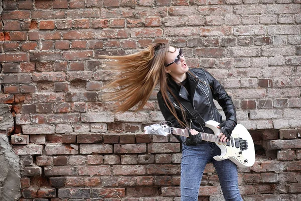 Ένα κορίτσι μουσικός βράχου σε ένα δερμάτινο σακάκι με μια κιθάρα — Φωτογραφία Αρχείου