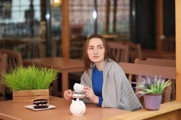 Junges Mädchen sitzt im Café und trinkt Tee — Stockfoto