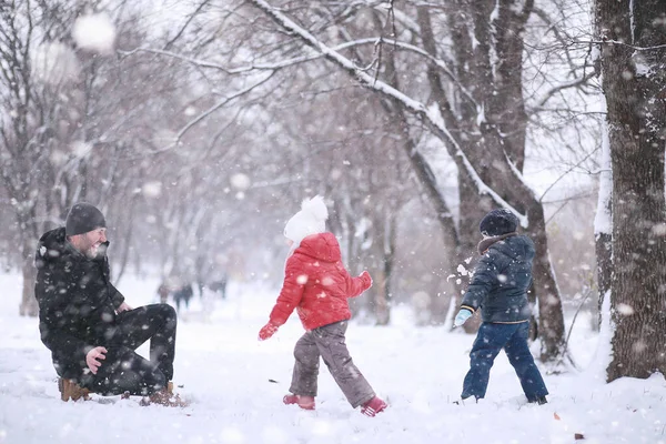 Los niños caminan en el parque primera nieve —  Fotos de Stock