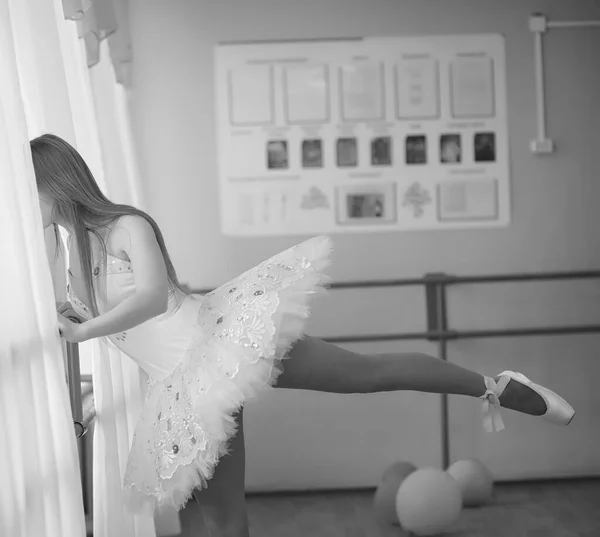 Joven bailarina de ballet en un calentamiento. La bailarina se está preparando para —  Fotos de Stock