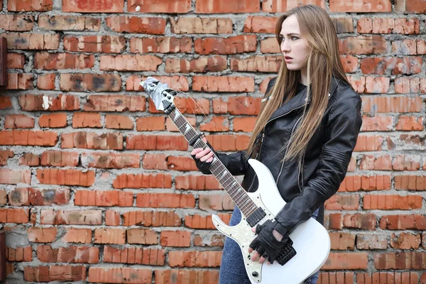 A rock musician girl in a leather jacket with a guitar — Stock Photo, Image