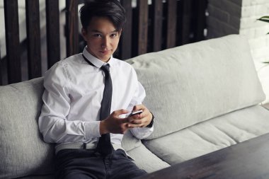 Genç Asyalı işadamı bir kafede bir ortak için bekliyor. Bu