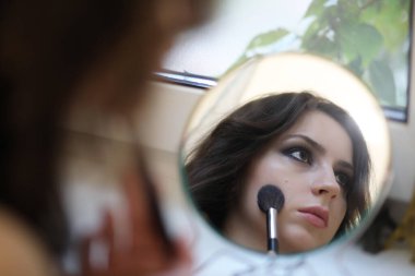 Güzel kız makyaj yapıyor.