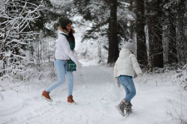 Genç bir aile yürüyüşe çıktı. Anne ve kızı şarapla yürüyorlar.