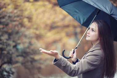 Sonbahar yağmurlu hava ve bir şemsiye ile genç bir adam