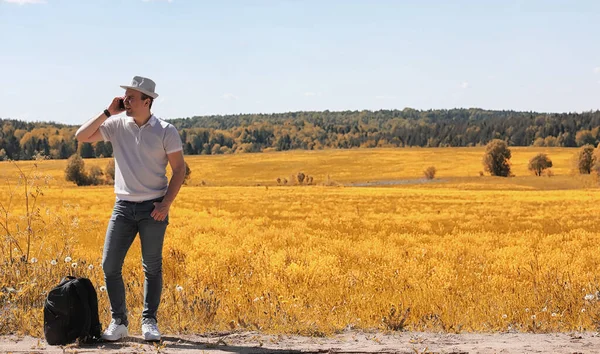 A young man is traveling in nature. Traveling with a backpack on — Stock Photo, Image