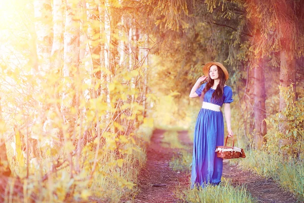 Menina bonita nova em vestidos na natureza. Uma menina de chapéu caminha — Fotografia de Stock