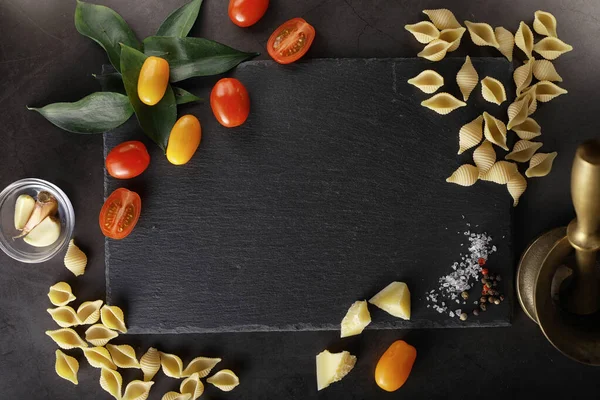 Nudelschalen auf schwarzem Stein. Tomaten und Lorbeerblätter mit Pallspi — Stockfoto