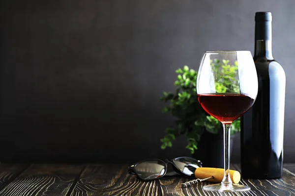 stock image A glass of red dry wine on the table. Dark bottle and glass of w