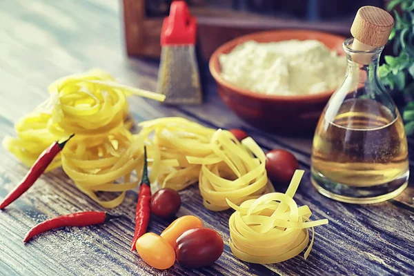 Pasta cruda sul tavolo. Tagliatelle sotto forma di nidi . — Foto Stock