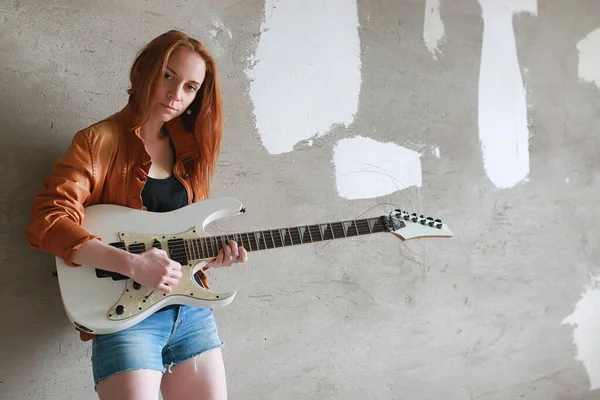 Menina ruiva jovem com uma guitarra elétrica. Músico de rock gir — Fotografia de Stock