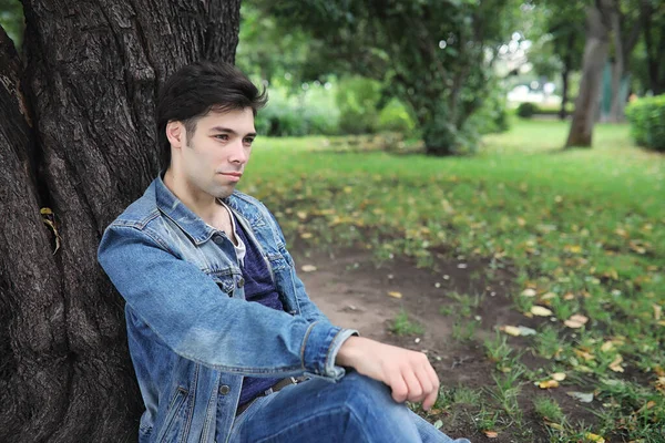 A young man walks in the park at lunch time. A man is on a walk