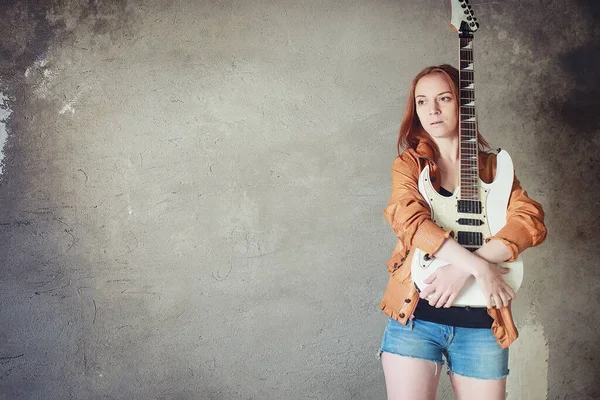 Menina ruiva jovem com uma guitarra elétrica. Músico de rock gir — Fotografia de Stock