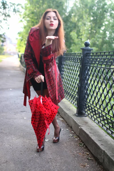 Mulher com guarda-chuva vermelho na árvore de rua — Fotografia de Stock