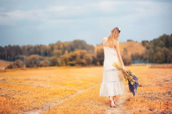 Meisje met een boeket van bloemen in de herfst — Stockfoto