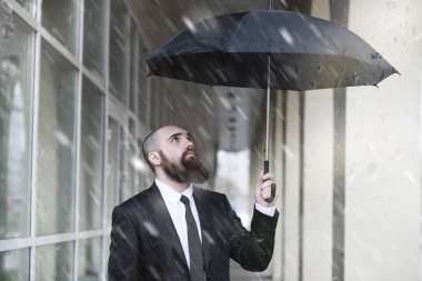 Takım elbiseli kel sakallı bir adam.