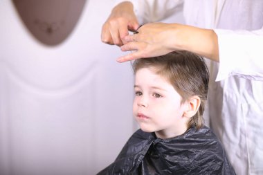 Kuaför ve çocuk. Çocuk saçını yapıyor. Kes saç çocuk i