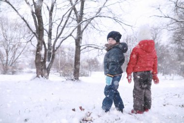 Çocuklar parkta ilk kar yürümek