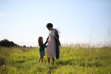 Anne ve kızı yolda yürüyor.
