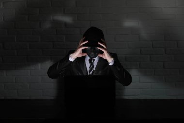Siyah maske ve hood masada hacker