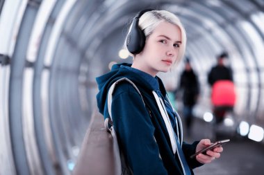 Genç öğrenci metro büyük kulaklıklar müzik dinlemek