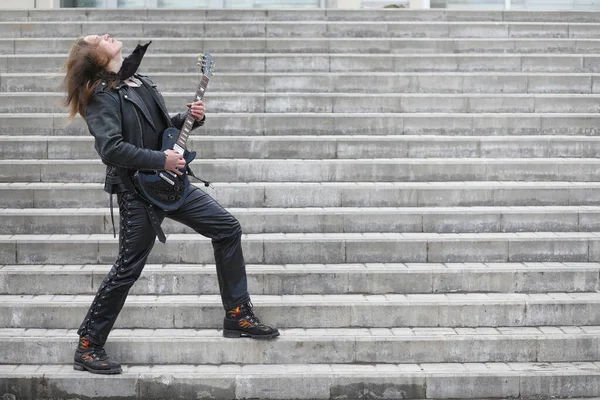 Rockgitarist op de trappen. Een muzikant met een basgitaar in een — Stockfoto