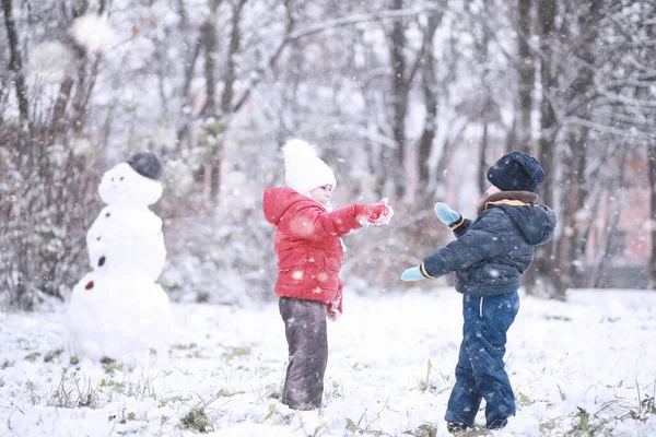 Los niños caminan en el parque primera nieve — Foto de Stock