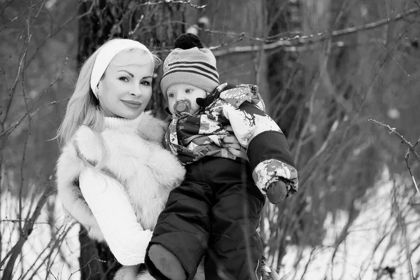 Mladá maminka chodí na zimní den s dítětem v náručí — Stock fotografie