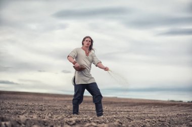 Genç bir köylü tahıl alanıyla sows