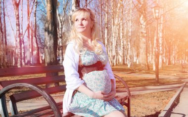 Hamile kız parkta bir yürüyüş. CI karnından kızla