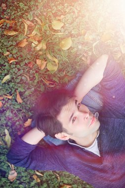 Genç bir adam öğle yemeği zamanında parkta yürür. Bir adam yürüyüşe çıktı. 