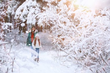 Genç bir aile yürüyüşe çıktı. Anne ve kızı şarapla yürüyorlar.