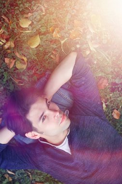 Genç bir adam öğle yemeği zamanında parkta yürür. Bir adam yürüyüşe çıktı. 