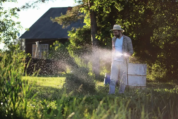 Hombre agricultor regando un huerto — Foto de Stock