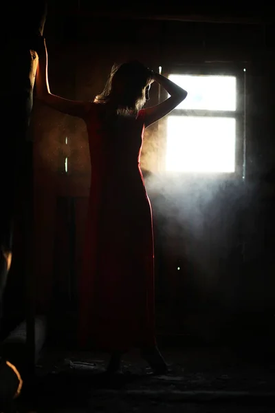 Silhouette di una bella ragazza in un vestito rosso — Foto Stock