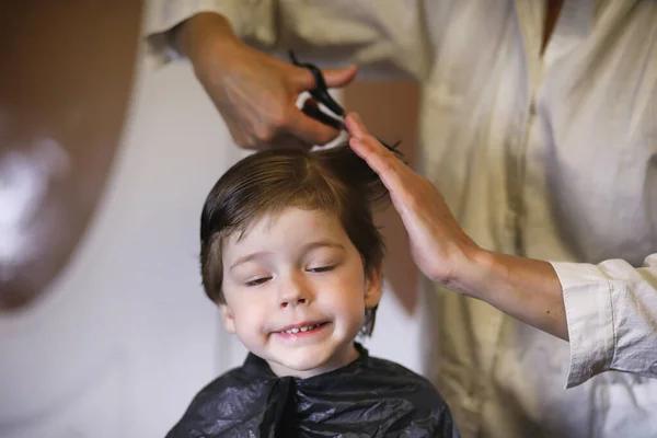 Hairdresser and boy. The boy is doing his hair. Cut hair child i