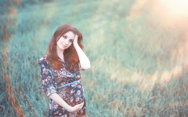 Menina grávida em um vestido na natureza — Fotografia de Stock