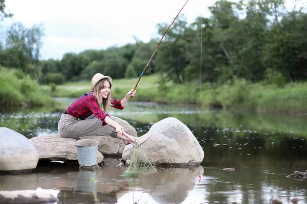 Ragazza vicino al fiume con una canna da pesca — Foto Stock