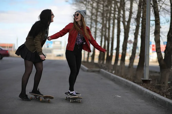 Een meisje van jonge hipster is een skateboard rijden. Meisjes vriendinnen f — Stockfoto